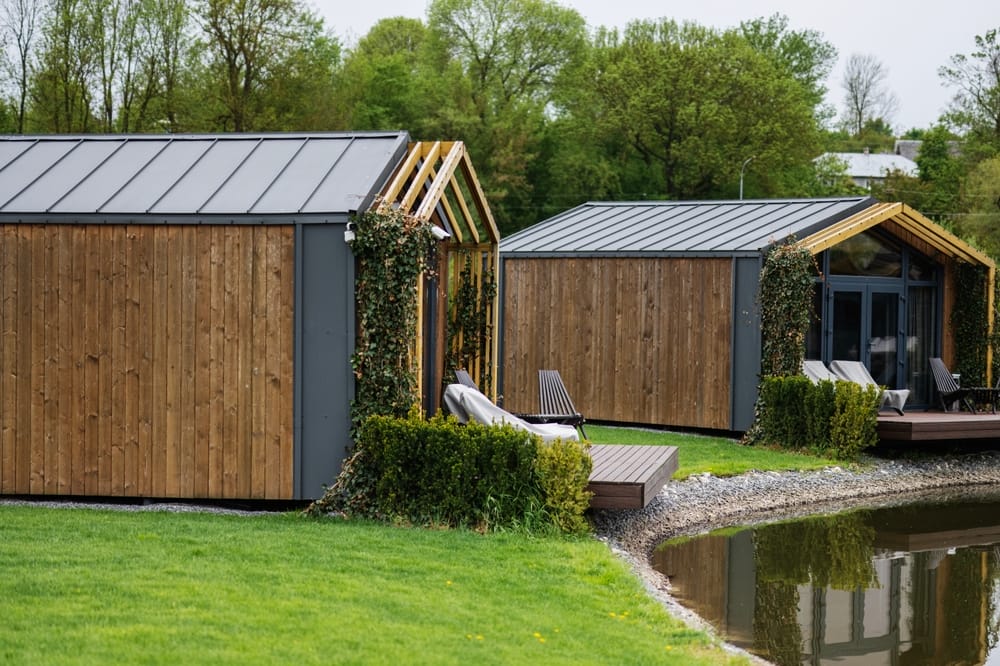 wooden,cabins,by,a,pond,surrounded,by,greenery,and,trees